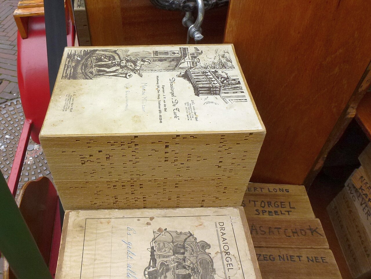 Figure 2 — A fan-folded cardboard music book, perforations cut across its width, folded concertina-style to feed the keyframe