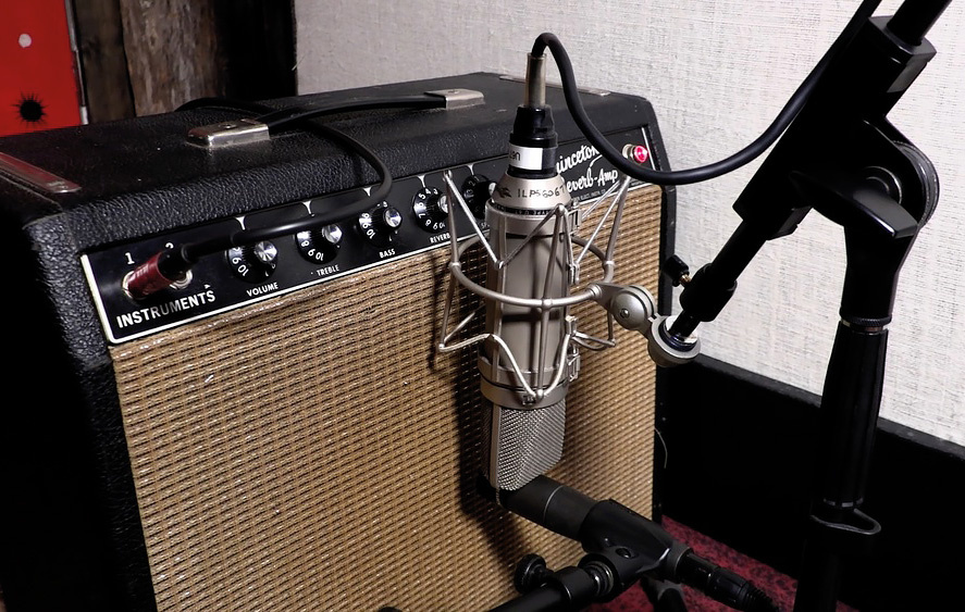 Figure 2 — A combo amplifier being close-mic'd with a dynamic microphone — the amp-capture path for a Rhodes, recording the speaker and amp color rather than the clean DI signal. Reference image.