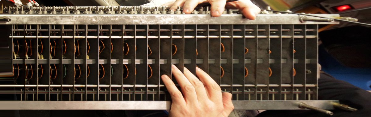 Underside of a Hammond tonewheel generator (a 1946 CV, mechanically identical to the B-3's), showing the tonewheels, the magnet-coil pickups, and the gear-driven shaft assembly that feed the matchi…