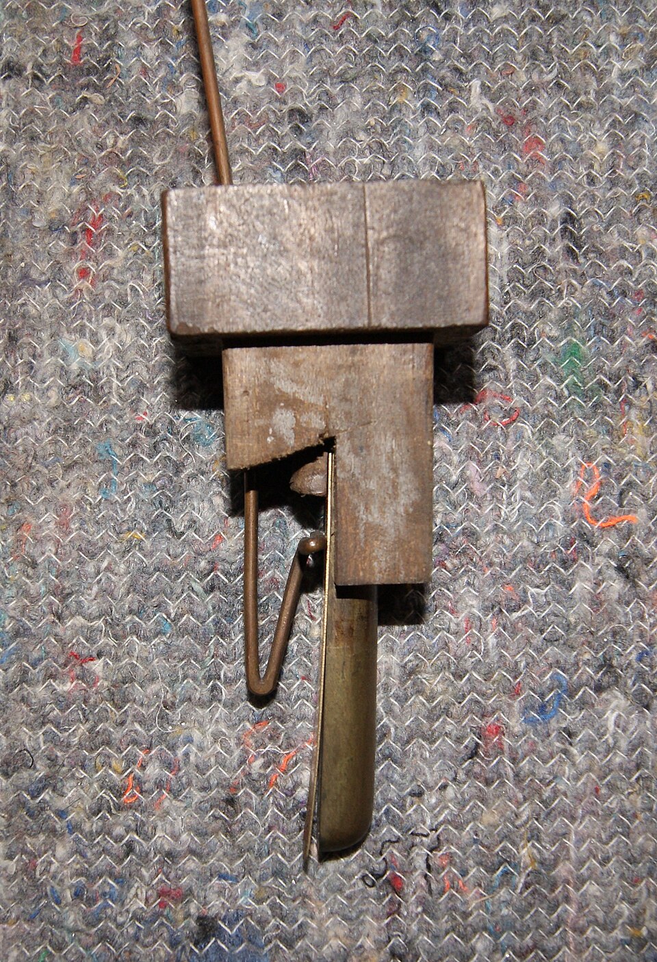 Figure 2 — A reed (lingual) pipe disassembled: brass tongue, shallot, block, wedge and tuning wire lifted out of the boot, with the resonator above — the buzzing-valve family used for Trumpet, Oboe, Clarinet …