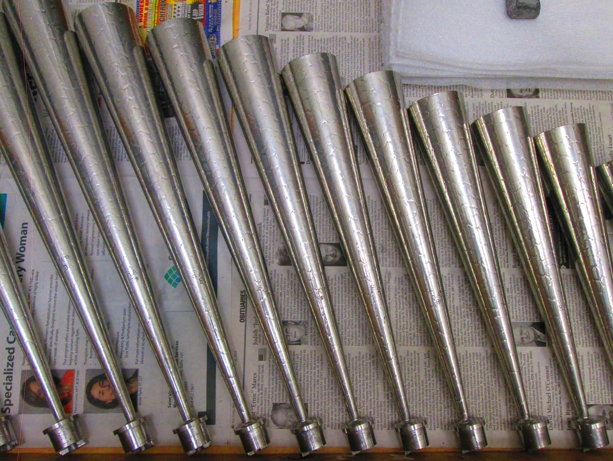 Figure 2 — Front-facing metal flue pipes in spotted metal, the mottled tin/lead alloy (~50 % tin) whose tin-rich crystals in a lead matrix give the leopard-spot surface prized for Principal and chorus ranks.
