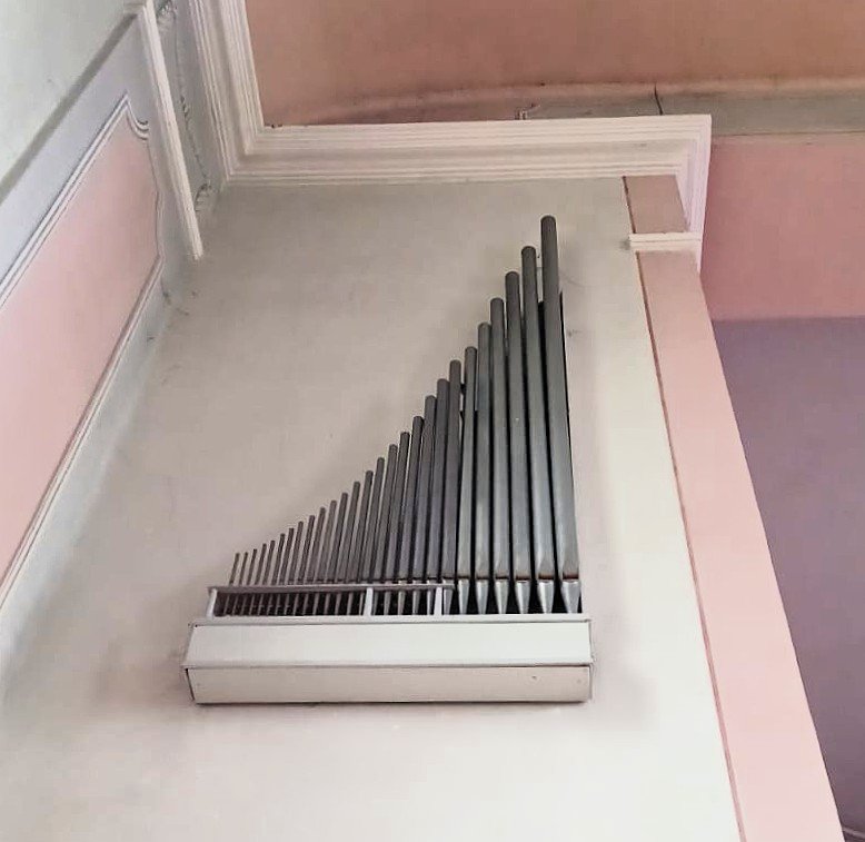 Figure 2 — A narrow-scale string pipe (Viole/Gamba, note the slender body and mouth beard) beside a wide-scale open flute of the same pitch — the diameter difference that separates a keen, harmonic-rich tone …