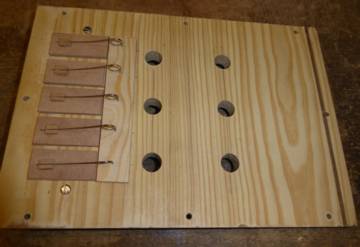 Figure 3 — John Smith melody pipes with their front covers held on by rubber bands during voicing, so the cover can be slid to sweep the cut-up before it is glued at the best-tone mark.