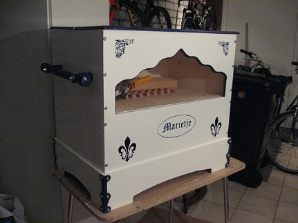 Figure 3 — "Little Mary" (Marietje), a 42-note hybrid organ (42 notes from a 51-key Limonaire scheme, 86 mahogany pipes) that plays from both MIDI files and paper rolls, with a Delft-blue painted case.